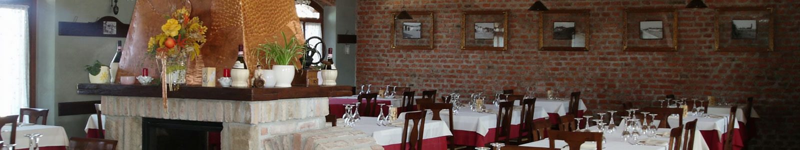La sala del ristorante con il camino e le pareti in mattoni
